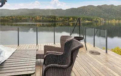 a couple of chairs sitting on a dock next to a lake at Nice Home In Follafoss With Lake View in Sela
