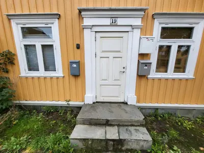 a house with a white door and two windows at Mars Modern and Cozy Apartment in the centre, Free Parking in Trondheim