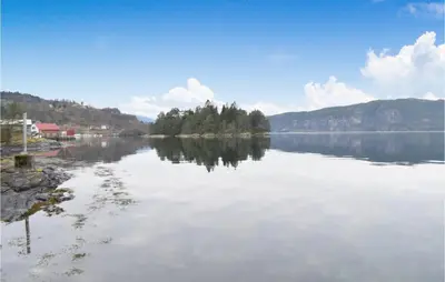 a large body of water with trees on the shore at Nice Home In Eikelandsosen With Sauna in Eikelandsosen