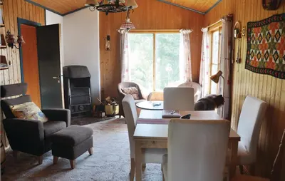 a dining room with a table and chairs with a laptop at Nice Home In Eikelandsosen With Sauna in Eikelandsosen