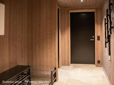 a hallway with a black door and wooden walls at Hafjelltunet in Hafjell