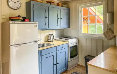 a kitchen with blue cabinets and a white refrigerator at Lovely Home In Eggedal With Wifi in Eggedal
