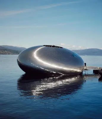 a large silver boat sitting on the water at Apartment by the fjord in Storekra
