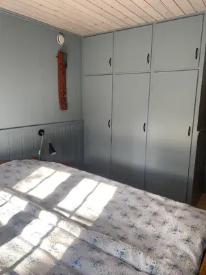 a bedroom with a bed and some white cabinets at Hallingstue by Hallstensgaard - Geilo in Geilo