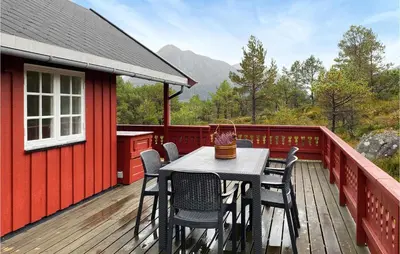 a table and chairs on the deck of a red house at Beautiful Home In Tustna With Wifi in Gullstein