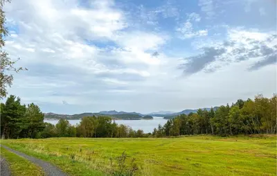 a road through a field with a view of a lake at Beautiful Home In Tustna With Wifi in Gullstein