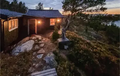 a small house with lights on the side of it at Cozy Home In Kjørsvikbugen With Wifi in Taftøya