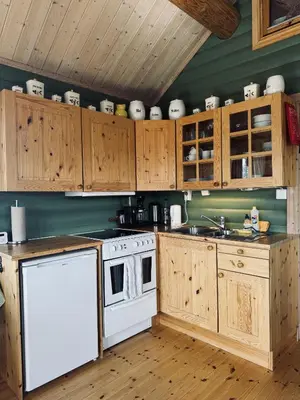 a kitchen with wooden cabinets and a white stove top oven at Cottage Yard - cozy Cabin in Geilo