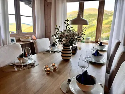 a dining room table with a vase of flowers on it at Skarsnuten Fjellandsby 23, Hemsedal, Ski-in/out in Hemsedal