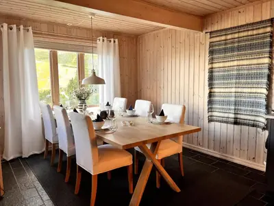 a dining room with a wooden table and white chairs at Skarsnuten Fjellandsby 23, Hemsedal, Ski-in/out in Hemsedal