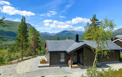 a house on a hill with mountains in the background at Cozy Home In Bjorli With Wifi in Bjorli