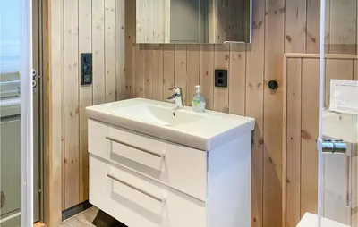 a bathroom with a white sink and wooden walls at Cozy Home In Bjorli With Wifi in Bjorli