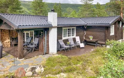 a log cabin with chairs and a deck at Beautiful Home In Bjorli in Bjorli