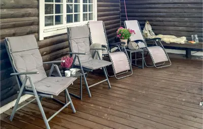 four chairs and a table with a dog on a porch at Beautiful Home In Bjorli in Bjorli