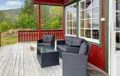 a screened in porch with two chairs and a glass table at 2 Bedroom Stunning Home In Foldfjorden in Skogli