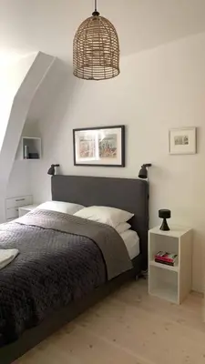 a bedroom with a bed and a pendant light at Stunning penthouse in the city! in Ålesund