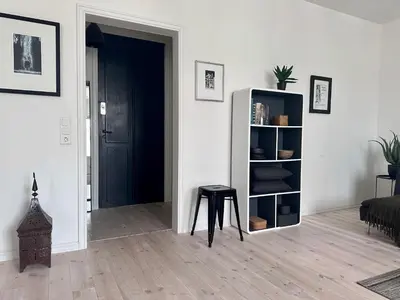 a living room with a book shelf and a stool at Stunning penthouse in the city! in Ålesund