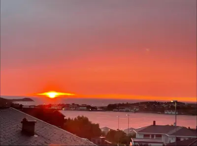 a sunset over the water with the sun in the sky at Eksluzywny apartament w zaciszu in Kristiansund