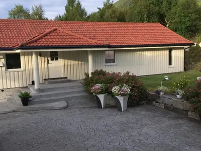 a house with two vases of flowers in front of it at Sivert´s kontorhotell in Tomrefjord