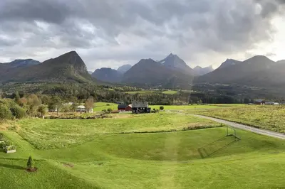 a view of a golf course with mountains in the background at Villa i Isfjorden! in Isfjorden