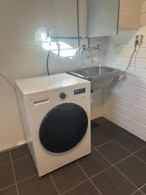 a washing machine in a kitchen next to a sink at A Cozy Place To Stay Over in Tysvær
