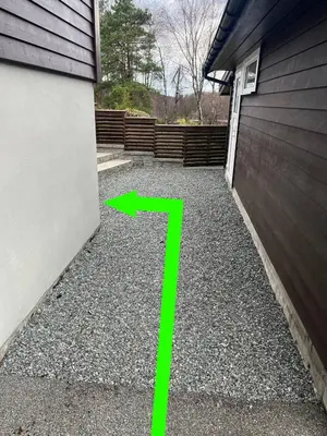 a driveway with a green number 7 next to a garage at A Cozy Place To Stay Over in Tysvær