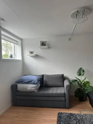 a living room with a couch and a window at A Cozy Place To Stay Over in Tysvær