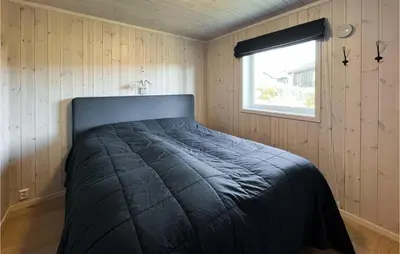 a bedroom with a bed in a room with a window at 4 Bedroom Lovely Home In Lillehammer in Lillehammer