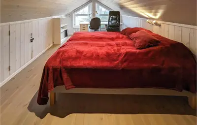 a bedroom with a large bed with a red blanket at 4 Bedroom Lovely Home In Lillehammer in Lillehammer