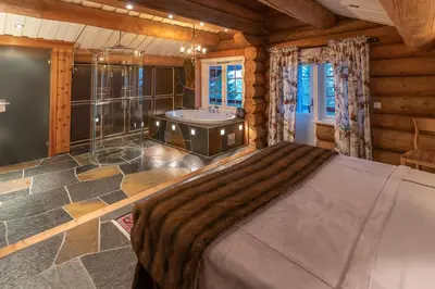 a bedroom with a large bed and a bath tub at Chalet De Luxe 518 in Trysil