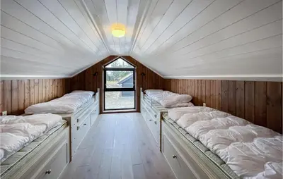 a row of beds in a room with a window at Cozy Home In Sjusjøen With Kitchen in Sjusjøen