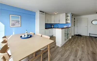 a kitchen and dining room with blue walls and a wooden table at Cozy Apartment In Uggdal With Wifi in Uggdal