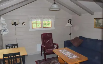 a living room with a blue couch and a table at Hesthaug Gard in Eidsdal