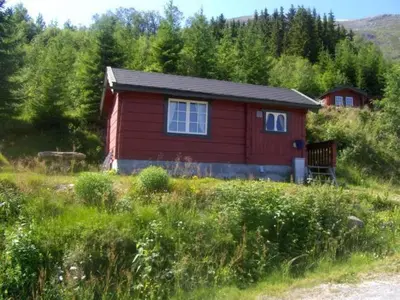 a red house in the middle of a field at Hesthaug Gard in Eidsdal