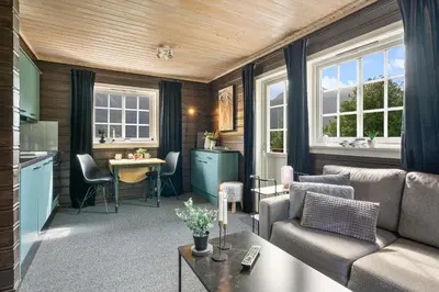 a living room with a couch and a table at Hygge Hütte - zwischen Fjell und Fjord in Lauvstad