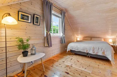 a bedroom with a bed and a table and a window at Hygge Hütte - zwischen Fjell und Fjord in Lauvstad