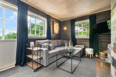 a living room with a couch and a tv at Hygge Hütte - zwischen Fjell und Fjord in Lauvstad