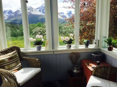 a room with windows with a view of mountains at Kavli gjestehus - Isfjorden. in Isfjorden