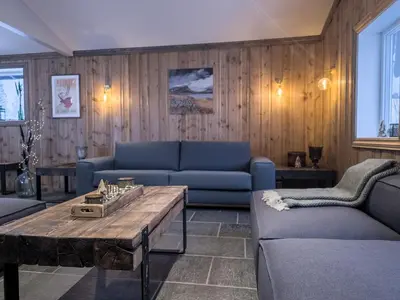 a living room with a blue couch and a table at Huso Mountain Lodge - Hemsedal in Eikregardane