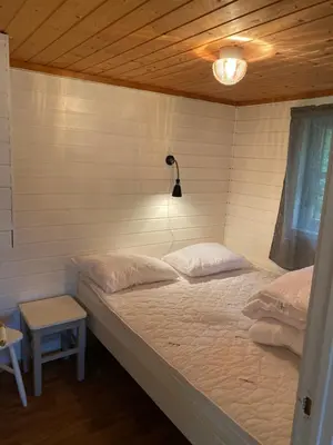a bedroom with a bed with a light on the wall at Nygård Camping in Hjelle