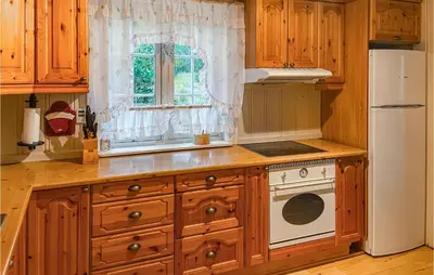 a kitchen with wooden cabinets and a white refrigerator at Cozy Home In Østby With Wifi in Trysil