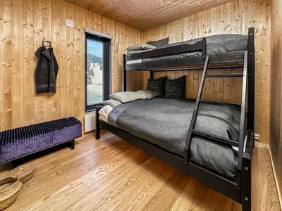 a bedroom with a bunk bed in a wooden wall at Ski-in-out hytte på Kvitfjell in Strande