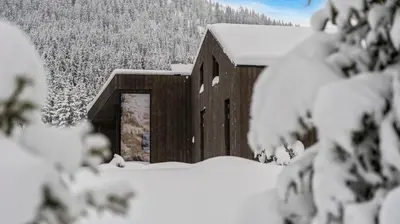 a barn covered in snow with snow covered trees at Ski-in-out hytte på Kvitfjell in Strande
