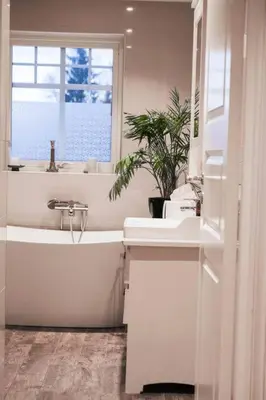 a bathroom with a tub and a sink and a window at Beautiful Private Villa with Lake View and Boat in Hålland