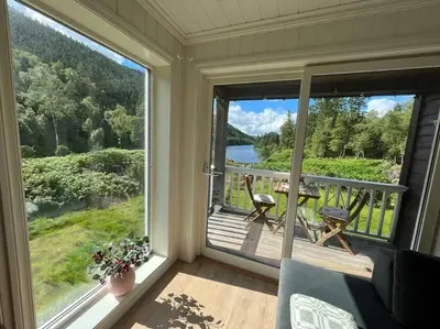 a screened in porch with a view of a lake at Beautiful Private Villa with Lake View and Boat in Hålland