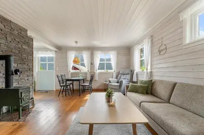 a living room with a couch and a table at Fjord Lodge direkt am Ufer des Dalsfjord in Lauvstad