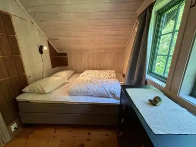 a bed in a tiny house with a window at Cabin with a great view at Gaustablikk in Gaustablikk