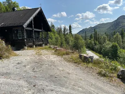 a cabin on a dirt road next to a dirt road at Cabin with a great view at Gaustablikk in Gaustablikk