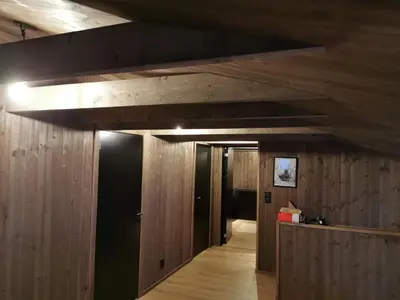 a hallway with wood paneling and a ceiling with a light at Moderne hytte i Svandalen, Sauda - nær skisenter og natur in Sauda