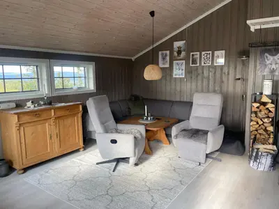a living room with two chairs and a table at Hytte med Anneks og fantastisk utsikt på Ljøsheim in Mesnali